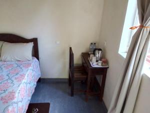 a bedroom with a bed and a desk with a chair at Recanto do Meu Tio in Chimoio
