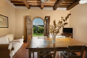 サン・ジミニャーノにあるAgriturismo Castello di Montautoのテーブルとソファのあるリビングルーム
