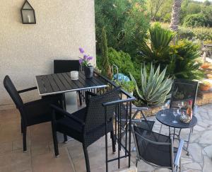 un patio con tavolo, sedie e piante di Marie Jean Chambre d'hotes & Gite a Oupia