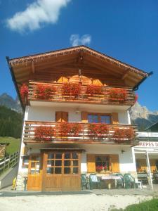 um edifício com caixas de flores na parte da frente em Chalet Crepes De Sela em Canazei