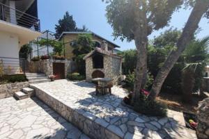 a house with a stone patio in front of a house at Penthouse apartment in Gornji Karin near the beach in Anić