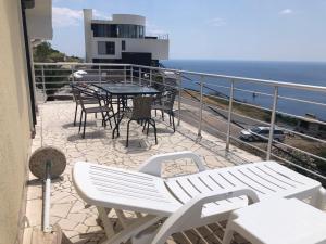 uma varanda com uma mesa e cadeiras e o oceano em Penthouse apartment with panoramic oceanview em Krimovice