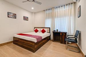 a bedroom with a bed and a desk and a chair at Hotel O Axom Inn in Barpeta