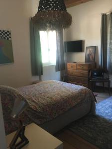 - une chambre avec un lit, une commode et une fenêtre dans l'établissement Magnifique Mas provençal dans le Luberon avec vue, à Pierrevert