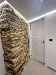 um quarto com uma parede de pedra ao lado de uma porta em Loft Anfiteatro Cudillero em Cudillero