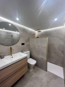 uma casa de banho com um lavatório, um WC e um espelho. em Loft Anfiteatro Cudillero em Cudillero