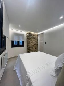a bedroom with a white bed and a window at Loft Anfiteatro Cudillero in Cudillero