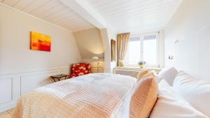 ein weißes Schlafzimmer mit einem Bett und einem Fenster in der Unterkunft Ruarklef in Kampen