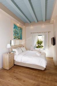 - une chambre avec un lit blanc et une fenêtre dans l'établissement Casa Antica, à Rhodes