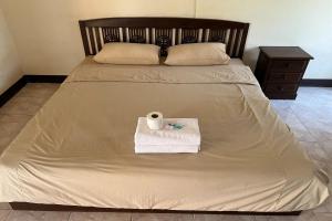 a bed with a towel and a roll of toilet paper on it at Sripoom House 1 in Chiang Mai