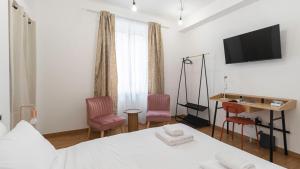 une chambre avec un lit et deux chaises et un bureau dans l'établissement Italianway - Confalonieri 11, à Milan