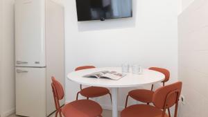 une table blanche avec des chaises et un réfrigérateur blanc dans l'établissement Italianway - Confalonieri 11, à Milan