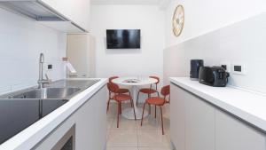 - une cuisine avec un évier et une table avec des tabourets dans l'établissement Italianway - Confalonieri 11, à Milan 32 autres photos