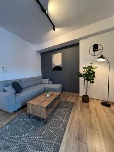 a living room with a blue couch and a coffee table at Green Escape Mavrovo in Mavrovo
