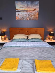 Māja- Linini في ماروب: غرفة نوم عليها سرير وفوط صفراء