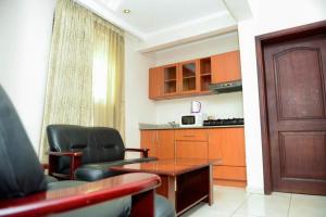 a living room with a table and chairs and a kitchen at Room in Apartment - Nobilis Senior Suite a very good choice for a great vacational experience in Kigali