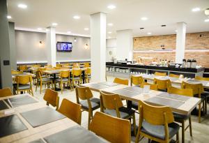 a restaurant with tables and chairs and a counter at Carlton Plaza Hotel Uberlandia in Uberlândia