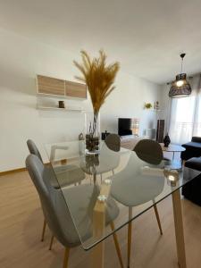 y sala de estar con mesa de comedor de cristal y sillas. en Cardenas Home Agata en Santa Fe