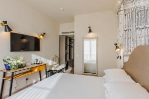 FH55 Grand Hotel Mediterraneo في فلورنسا: غرفة نوم بسرير ومكتب وتلفزيون