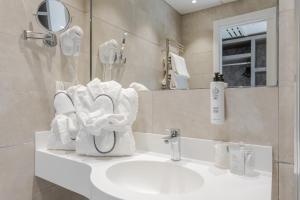 FH55 Grand Hotel Mediterraneo في فلورنسا: حمام مع حوض مع مناشف ومرآة