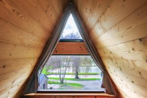 - une fenêtre dans une cabane en bois avec vue sur un parc dans l'établissement Cottage 2 chambres - Chalet climatisé pour 4, à Malzy 4 autres photos