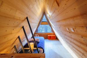 - une chambre dans une maison en bois avec une grande fenêtre dans l'établissement Cottage 2 chambres - Chalet climatisé pour 4, à Malzy