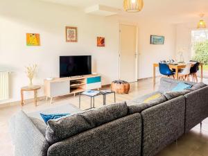 a living room with a couch and a tv at Maison moderne 6 pers avec jardin à 7 minutes des plages in Beaussais sur Mer