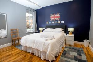 ein Schlafzimmer mit einem großen Bett mit blauer Wand in der Unterkunft Pass the Keys Lincoln room at Tavmar Apartments in Lincoln
