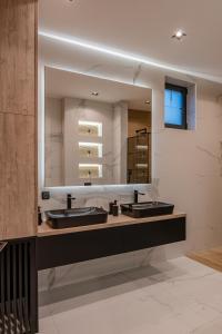 baño con 2 lavabos y espejo grande en Villa 4A, en Visoko