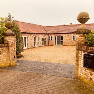 un antiguo edificio de ladrillo con un gran patio en The Stable's Barn in Bigby, en Barnetby le Wold