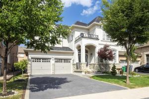 a white house with a garage at Luxurious Stay in the Heart of Community in Brampton