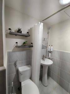 a white bathroom with a toilet and a sink at Seo staycation in Lapu Lapu City