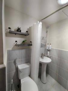 a white bathroom with a toilet and a sink at Seo staycation in Lapu Lapu City +5 photos
