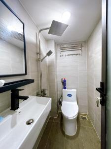 y baño con aseo blanco y lavamanos. en Alley Homestay Sai Gon, en Ho Chi Minh