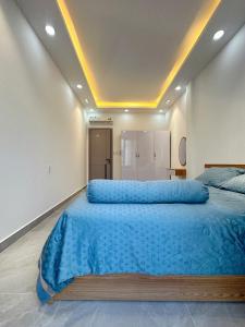 a large bedroom with a large bed with blue sheets at Alley Homestay Sai Gon in Ho Chi Minh City