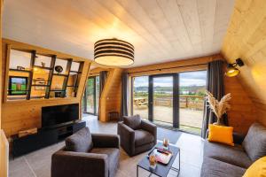 un soggiorno con divano, sedie e TV di Cottage 3 chambres - Chaleureux chalet pour 6 