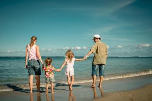 a family standing on the beach holding hands at Beautiful Chalet In The Seaside Village Of Scratby, Norfolk Ref 51054s in Great Yarmouth