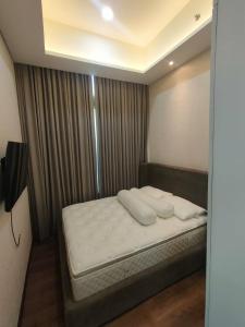 Een bed of bedden in een kamer bij super penthouse stmoritz apartment, lippomall puri indah