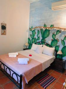 a bedroom with a bed with a painting of cactus at AMPELIA KYTHIRA in Livadi