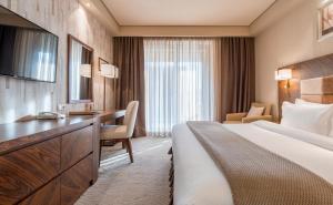 Pokój hotelowy z łóżkiem i biurkiem w obiekcie Dreamland Oasis Hotel w mieście Czakwi