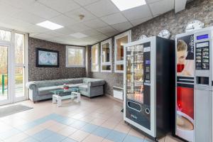 uma sala de estar com um sofá e uma máquina de venda automática em Hôtel La Nonette ASTERIX, CDG AIRPORT & PARIS CENTRE em Orry-la-Ville