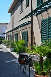 un tavolo e sedie di fronte a un edificio con piante di Hotel Delle Rose a San Bartolomeo al Mare