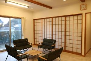 Vacation House YOKOMBO ANNEX في ناووشيما: غرفة انتظار مع كراسي وطاولة