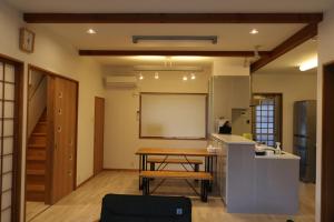 una cucina con tavolo in legno in una camera di Vacation House YOKOMBO ANNEX a Naoshima