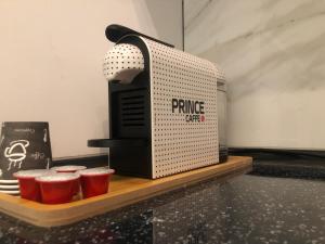 a coffee machine sitting on a counter with red cups at Daily Apartment Prishtina in Pristina