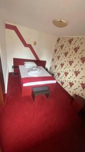a bedroom with a bed with a red carpet at Pension La Viorel Isaila in Sibiu
