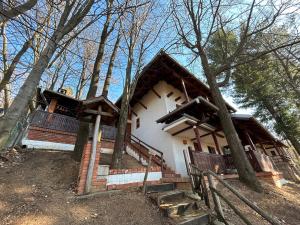 a house in the woods with a fence around it at Planinska kuca Bogdanovic in Jarmenovci
