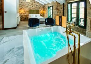 a bathtub with blue water in a room at Casa de Lema Boutique in Muxia