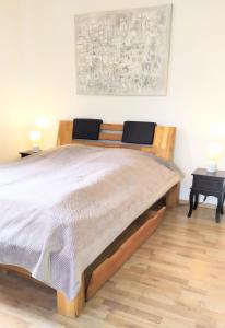 a large bed in a bedroom with two tables at Super Penthouse #9 oder Studio #6 mit Aufzug, Terrasse & Wintergarten im Zentrum in Eschweiler