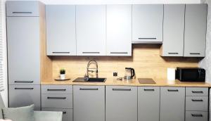 a kitchen with white cabinets and a sink at APARTAMENT JARACZA 28/10 in Słupsk